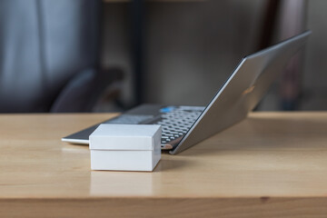 
White box on the background of a laptop on a work table close-up.