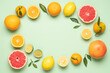 Creative neatly arranged food layout of fruits and leaves on pastel green background. Flat lay juicy citrus fruits 