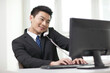 © eastfenceimage - Portrait of business man sitting by computer