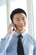 © eastfenceimage - Portrait of young businessman talking on cell phone in office