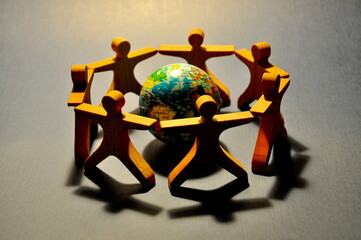 People holding hands around blue globe.  Community, union concept.