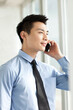 © eastfenceimage - Portrait of young businessman talking on cell phone in office