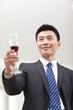 © eastfenceimage - Portrait of businessman holding a glass of wine