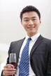 © eastfenceimage - Portrait of businessman holding a glass of wine