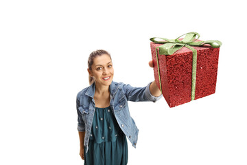 Canvas Print - Young woman holding a sparkly red present in front of camera