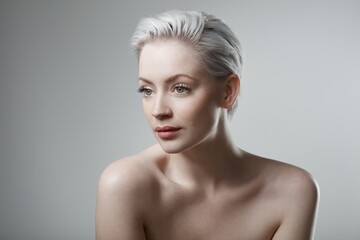 Beautiful young woman with bare shoulders looking away.