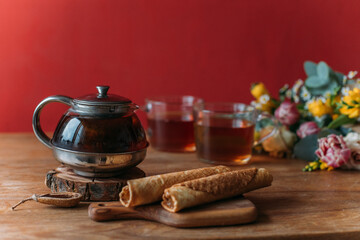 Wall Mural - Still life. A table with a teapot, mugs and flowers