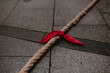 Lazo rojo en una cuerda marrón apoyado en el suelo preparado para jugar a Soka tira, deporte tradicional del país vasco.