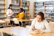 © JackF - Interested young Latina spending time in library, reading books and making notes. Self-education concept