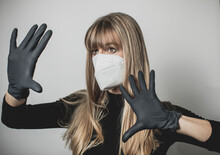 Young, Blond Beautiful Woman Puts Ffp2 Protective Mask On With Protective Medical Gloves For Protection Against Corona