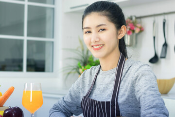 Healthy Asian women prepare food in their kitchen with fruits and vegetables loaded with vitamin C.