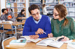 © JackF - Portrait of smiling female and male students working in university library