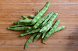 Top view closeup of fresh green beans on a wooden table
