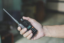 The Hand Of A Man Holding A Walkie-talkie Radio