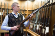 © JackF - Seller demonstrates a combat winchester in the gun store