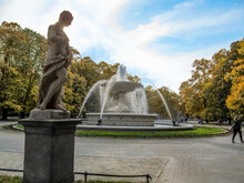Rococo Sculpture And Fountain In The Saxon Garden In Warsaw On An Autumn Day. Beautiful Old Public Park With Yellow Trees In The Capital Of Poland