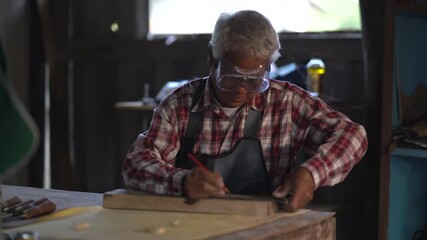 Wall Mural - Carpenter working on wood in carpentry shop. the man works in a carpentry shop