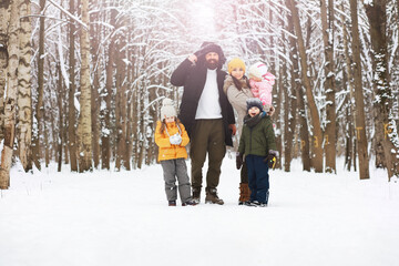 Happy family playing and laughing in winter outdoors in the snow. City park winter day.