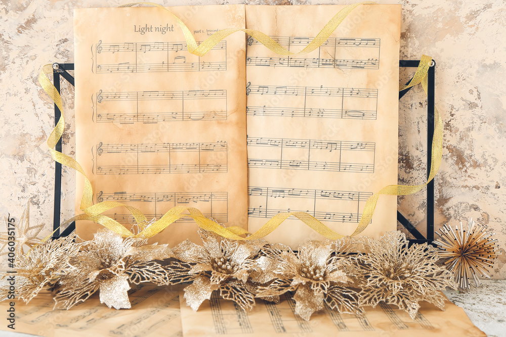 Music sheets with notes and Christmas decor on table