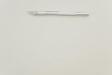 Poster - Top view of the metallic scalpel isolated on light gray background