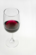 © Natalia - Vertical shot. A glass of red wine on a light background.