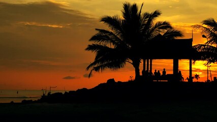 Wall Mural - Silhouettes of people meet tropical sunset sky