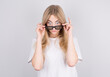 © Studio Nova - Young woman with glasses is very surprised looking down and lowering her glasses. Surprise and shopping concept on white background.