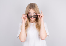 Young Woman With Glasses Is Very Surprised Looking Down And Lowering Her Glasses. Surprise And Shopping Concept On White Background.