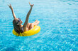 © F8  \ Suport Ukraine - Young woman with perfect sexy body in bikini and glamorous sunglasses, posing on an inflatable yellow ring in the swimming pool outdoors