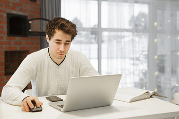 Wall Mural - A man working on a laptop at home at bright kitchen