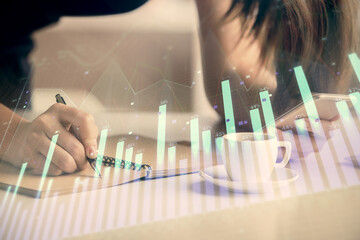 Double exposure of forex graph sketch hologram and woman holding and using a mobile device. Stock market concept.