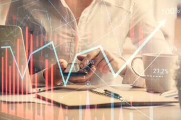 Double exposure of forex chart sketch hologram and woman holding and using a mobile device. Financial market concept.