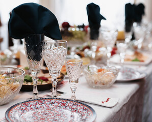 glasses for wine and drinks on the laid festive table in the restaurant