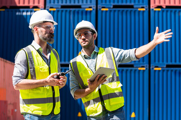 Wall Mural - Logistics engineer and inspector working togetter and discussing in shipping containerin commercial transport port