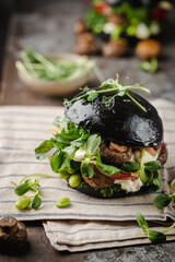 Wall Mural - Veggie mushroom, green salad and vegetable black burgers. on gray stone background Copyspace.