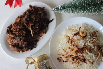 Wall Mural - Aromatic traditional Ghee rice and spicy mutton roast prepared in Kerala style photographed with Christmas settings