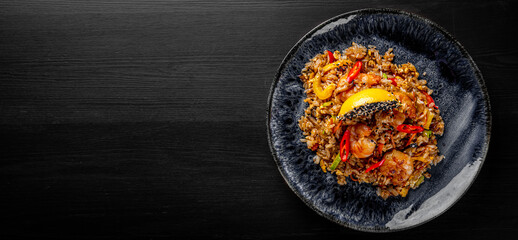 Wall Mural - Fried rice with shrimp and vegetables in plate on wooden table background