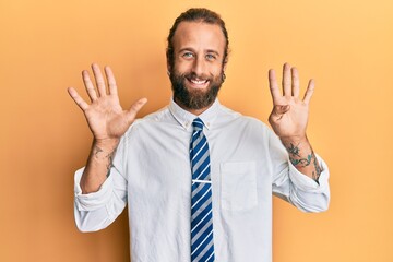 Handsome man with beard and long hair wearing business clothes showing and pointing up with fingers number nine while smiling confident and happy.