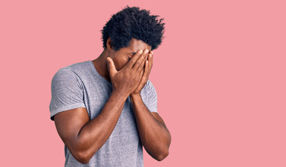 Poster - Handsome african american man with afro hair wearing casual clothes with sad expression covering face with hands while crying. depression concept.