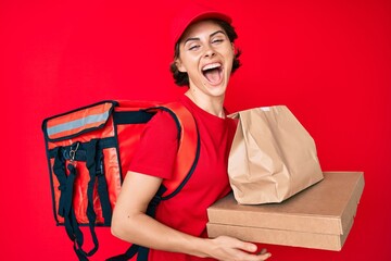 Poster - Young hispanic woman holding take away paper bag smiling and laughing hard out loud because funny crazy joke.