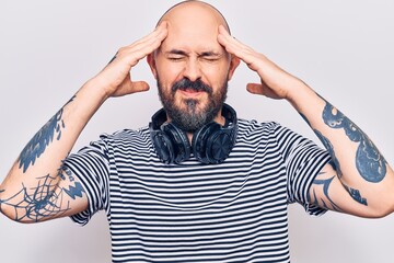 Poster - Young handsome man listening to music using headphones with hand on head, headache because stress. suffering migraine.