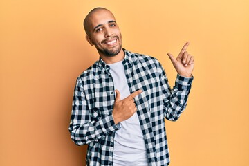 Canvas Print - Hispanic adult man wearing casual clothes smiling and looking at the camera pointing with two hands and fingers to the side.