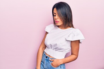 Wall Mural - Young beautiful brunette woman wearing casual clothes standing over isolated pink background