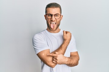 Canvas Print - Young caucasian man wearing band aid for vaccine injection sticking tongue out happy with funny expression.