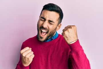 Young hispanic man wearing casual clothes celebrating surprised and amazed for success with arms raised and eyes closed. winner concept.