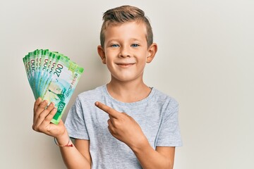 Wall Mural - Adorable caucasian kid holding russian 200 ruble banknotes smiling happy pointing with hand and finger