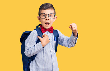 Wall Mural - Cute blond kid wearing nerd bow tie and backpack screaming proud, celebrating victory and success very excited with raised arms