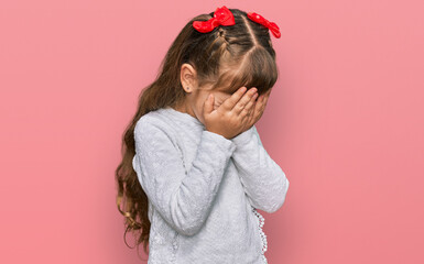 Little caucasian girl kid wearing casual clothes with sad expression covering face with hands while crying. depression concept.