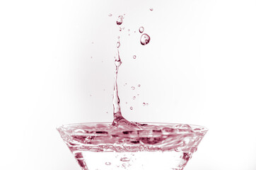 Canvas Print - Waterdrops dropping into a glass filled with water