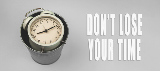 Inspirational and motivational quotes concept, don't lose your time background banner with alarm clock and trash bin